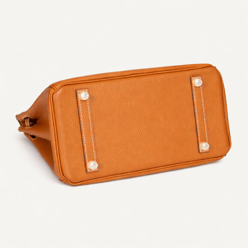 Orliná transparent feet stud protector installed on Hermès bag to prevent scratches