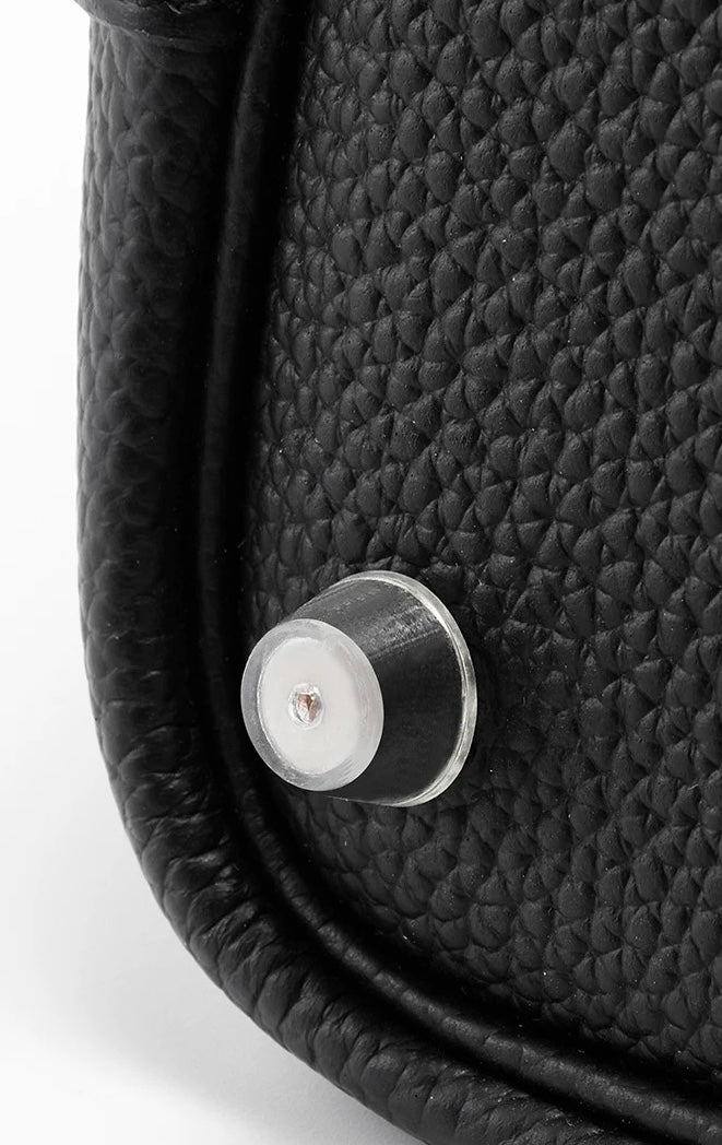 Orliná transparent feet stud protector installed on Hermès bag to prevent scratches