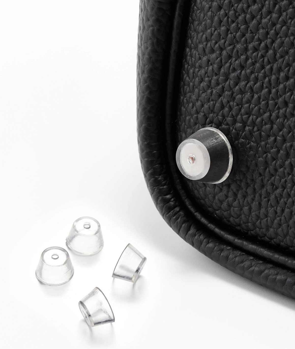 Orliná transparent feet stud protector installed on Hermès bag to prevent scratches