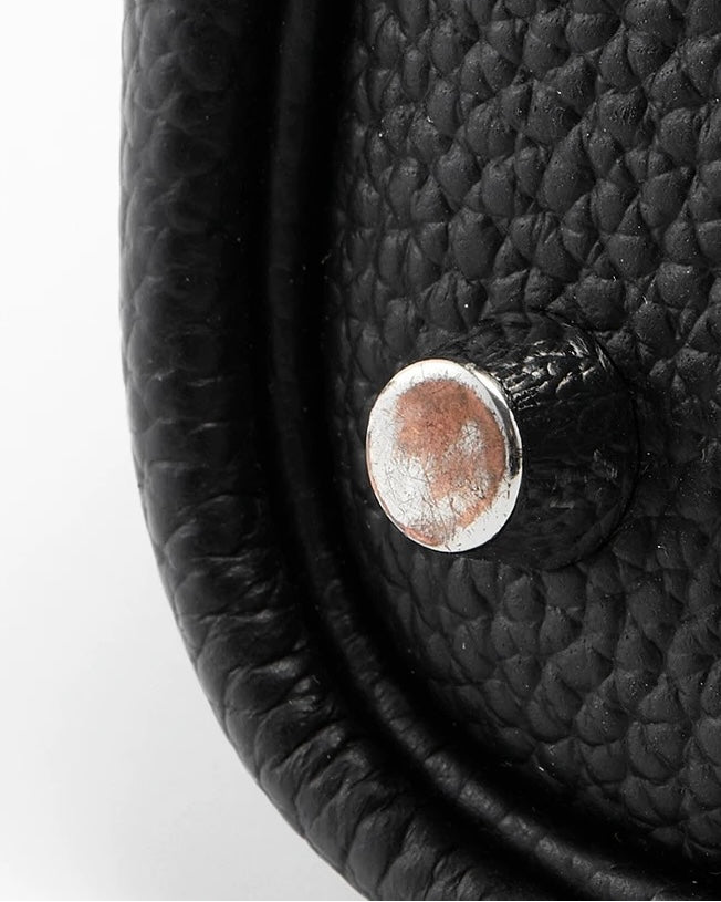 Close-up of scratched metal feet on Hermès Birkin 25