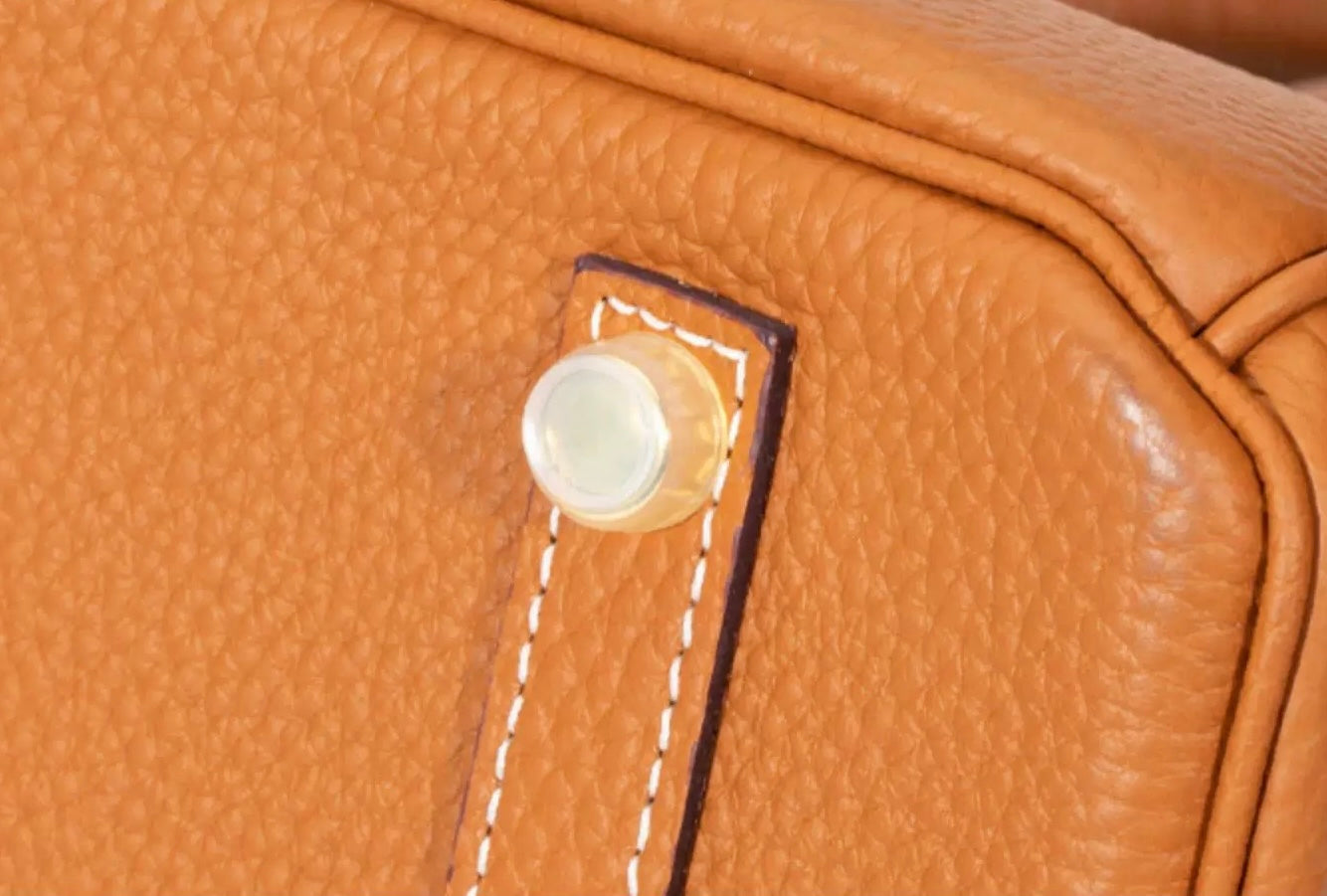 Close-up detail of Orliná transparent feet stud protector installed on Hermès bag base