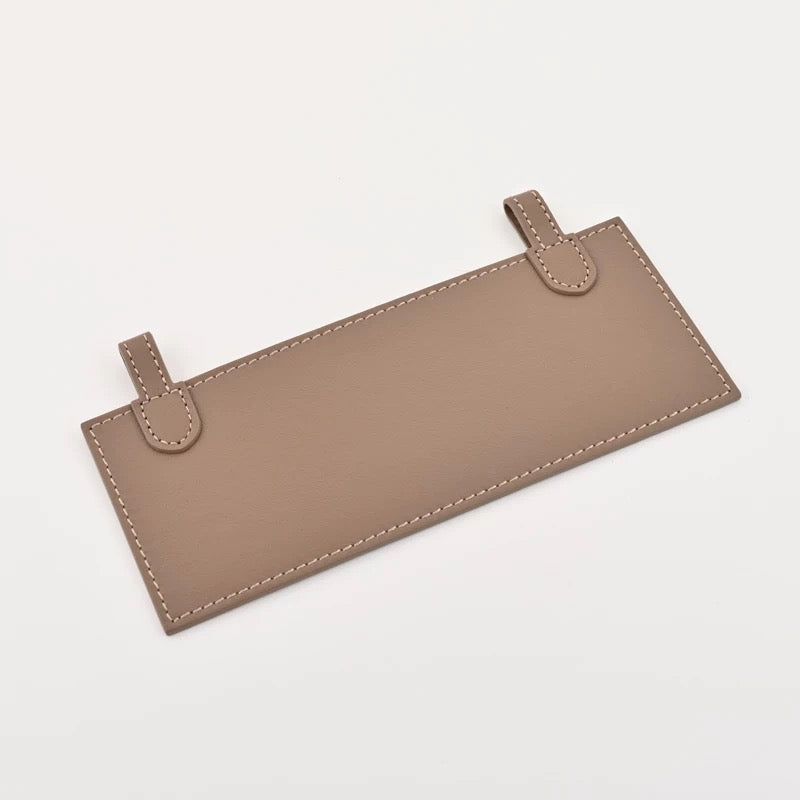 Leather insert inside Hermès Kelly Pochette for hands-free strap attachment in Hermès Etoupe colour
